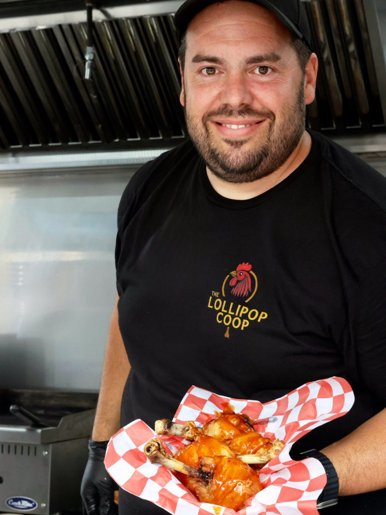Mike holding a basket of lollipop chicken drumsticks